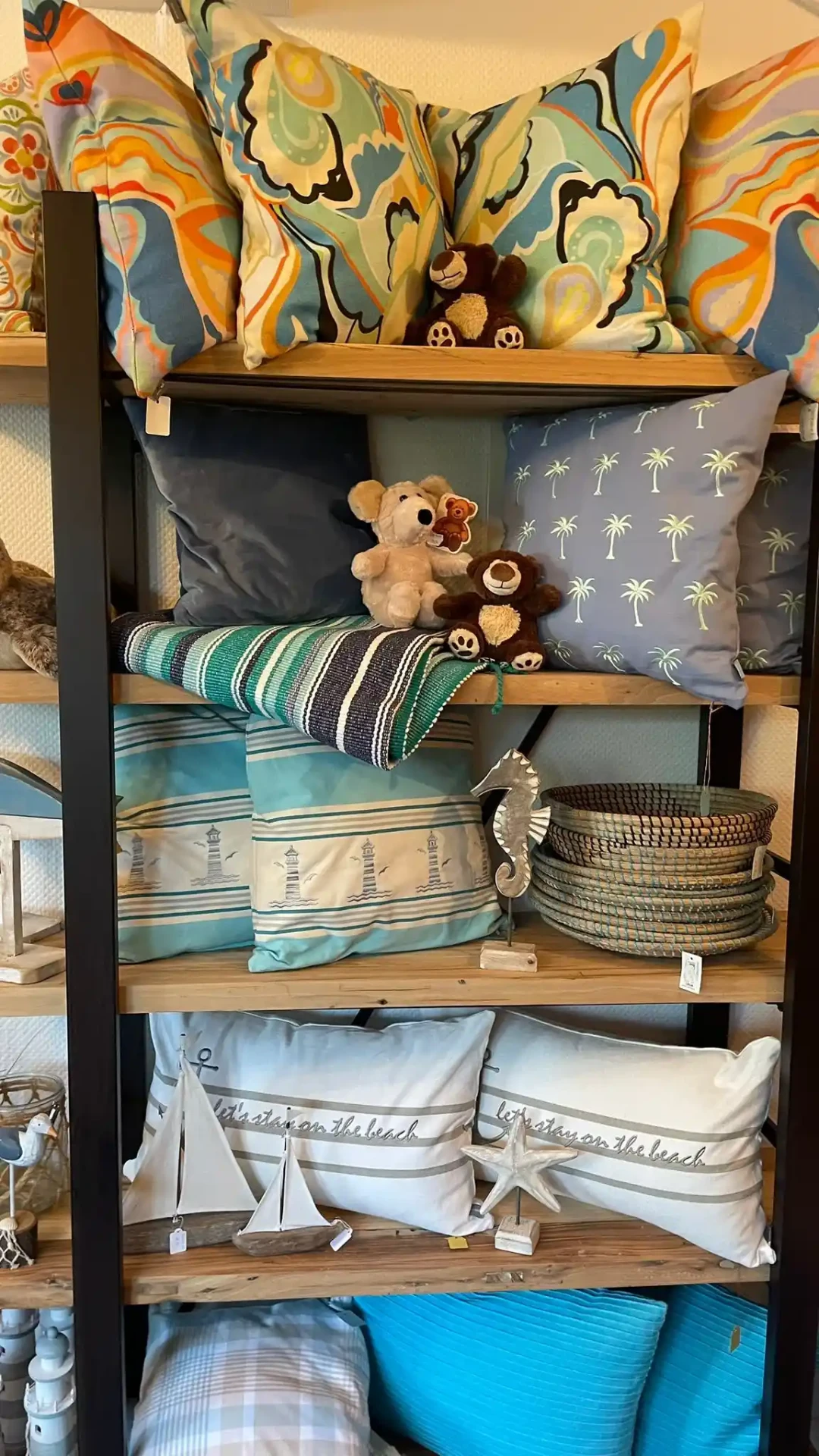 Regal mit maritimen Kissen, Leuchtturm-Motiven und Plüschtieren