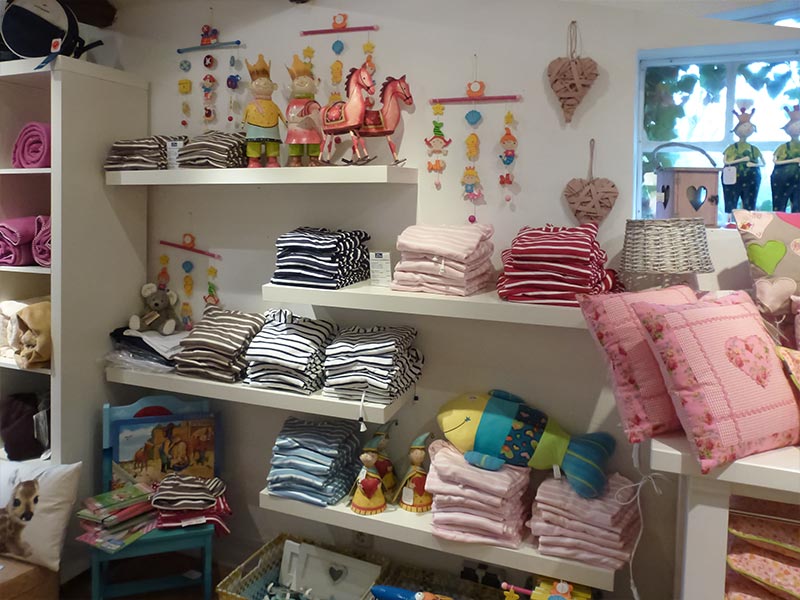 Kindermode und Kuscheltiere im Regal